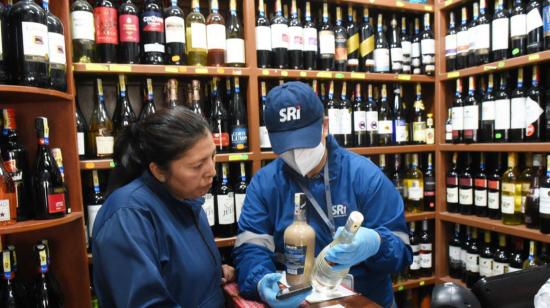 Un funcionario del SRI verifica los precios de una bebida alcohólica, el 1 de diciembre de 2022, en Quito.