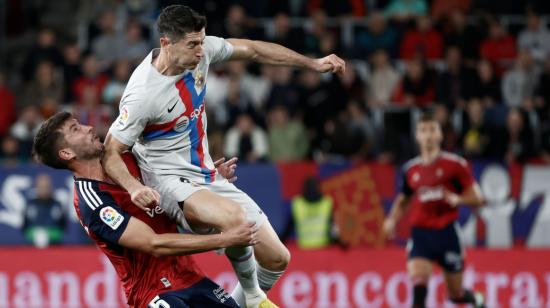 El delantero del FC Barcelona Robert Lewandowski golpea a David García, de Osasuna.