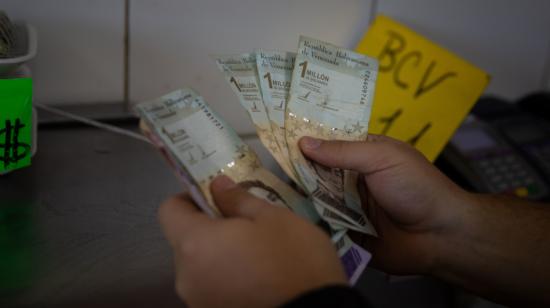 Un vendedor cuenta billetes de un millón de bolívares, el 23 de septiembre de 2022, en Caracas (Venezuela).