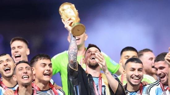 Lionel Messi levanta el trofeo de la Copa del Mundo y sus compañeros lo festejan, el 18 de diciembre de 2022.