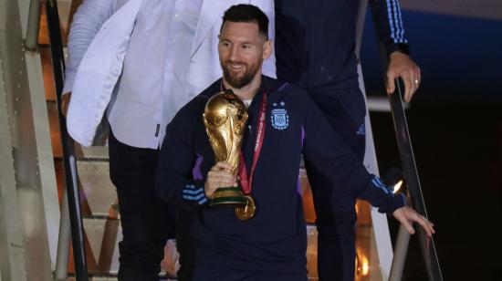 Lionel Messi desciende con el trofeo del Mundial de Fútbol Qatar 2022 a su llegada  al Aeropuerto Internacional de Ezeiza, el 20 de diciembre de 2022.