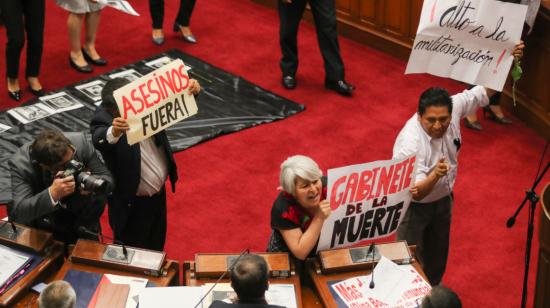 Congresistas de Perú sostienen pancartas con consignas contra el gobierno de Dina Boluarte, mientras le gritan al primer ministro de Perú, Alberto Otarola, el 10 de enero de 2023.