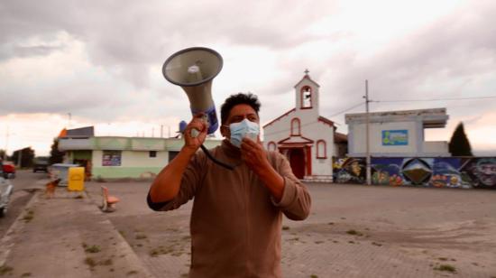 Una persona con un altavoz da instrucciones a quienes participan en el simulacro de evacuación en Mulaló, el 27 de enero de 2023.