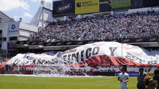 Los hinchas de Liga de Quito despliegan una bandera en una de las generales del estadio Rodrigo Paz Delgado, el 29 de enero de 2023.