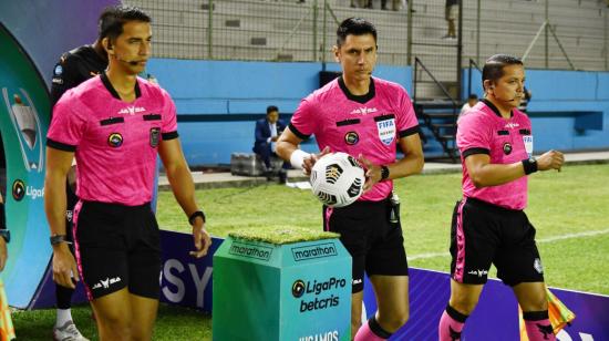 Los árbitros entran a la cancha en el partido de Delfín ante Liga, en el estadio Jocay, el 7 de octubre de 2022.