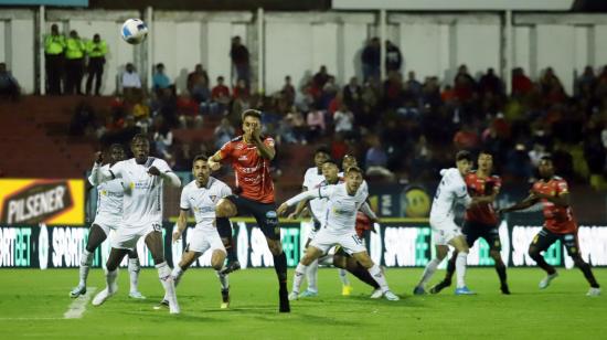 Los futbolistas del Deportivo Cuenca y Liga buscan un balón durante una jugada aérea por la Fecha 1 de la LigaPro 2023, el 24 de febrero.