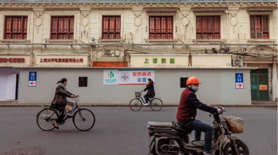 Varias personas pasan junto a una clínica improvisada para tratar el coronavirus en Shanghái, China, el 1 de marzo de 2023. 