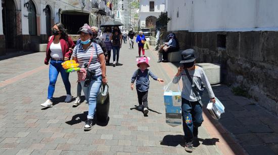 Dos niños y su madre venden productos en el Quito, el 25 de agosto de 2022.