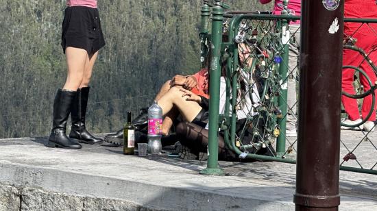 Jóvenes se sientan en el mirador a beber. 