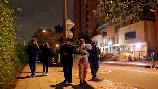 Varias personas salen de un edificio en Bogotá, tras sentir el sismo, el 10 de marzo de 2023. 