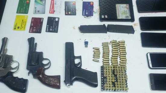 La Policía incautó armas de fuego, tarjetas de crédito, entre otros artículos, a los sospechosos de extorsión.