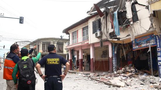 Personal de Gestión de Riesgos y Bomberos de Pasaje observan una de las viviendas destruidas en ese cantón por el terremoto del 18 de marzo de 2023.