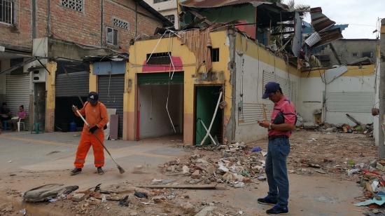 Obreros limpian el exterior de una casa colapsada tras el terremoto en las calles Boyacá y Páez, en el centro de Machala. 