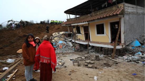 Tres personas junto a una vivienda derrumbada en Alausí, Chimborazo, el 27 de marzo de 2023. 