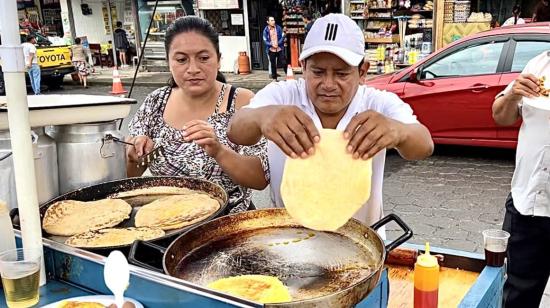 Susana y César preparan tortillas en su puesto frente al mercado Mariscal, en Puyo.