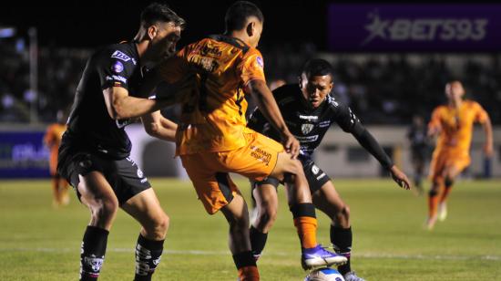 Dos jugadores de Independiente intentan recuperar la pelota en un partido ante Libertad, en Loja, el 14 de abril de 2023.