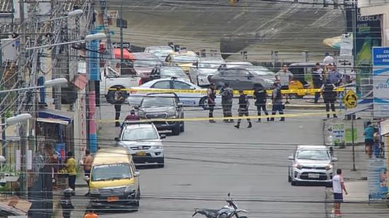 Detrás de los cables de alumbrado, se observa a policías que detonarán un artefacto explosivo dejado en Guayaquil, el 27 de abril de 2023. 