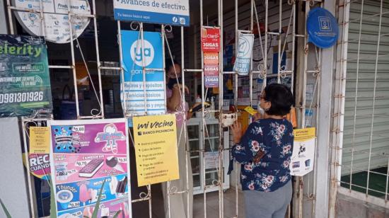 Imagen referencial de una persona comprando en una tienda de barrio.