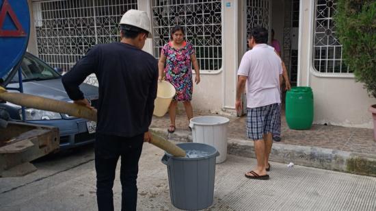 Un trabajador de Interagua abasteciendo del líquido a una vivienda en Guayaquil, abril de 2023. 