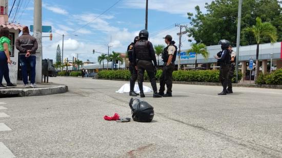 Varios policías parados junto al cuerpo de un presunto delincuente muerto en Guayaquil, el 3 de mayo de 2023. 