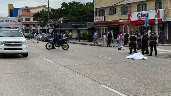 Policías junto a delincuente abatido, tras un enfrentamiento en la Garzota, norte de Guayaquil, el 3 de mayo de 2023. 