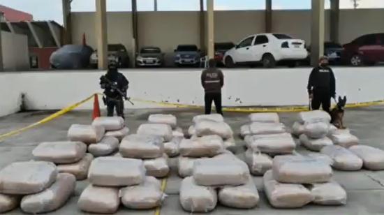 Policías posan junto a unos sacos de cocaían incautados en el puerto de Guayaquil, el 13 de mayo de 2023.