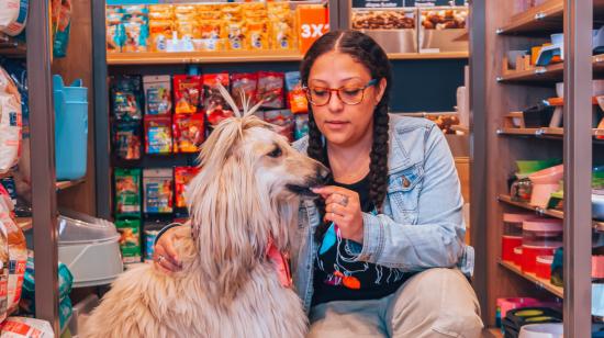 Kassiny, perra de Pet Station, junto a su tutora. Local en el norte de Quito, febrero de 2023. 