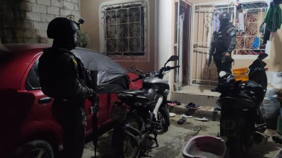 Dos policías de las fuerzas especiales afuera de una vivienda en Durán, Guayas, el 24 de mayo de 2023. 