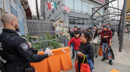 Decenas de migrantes de diferentes nacionalidades hacen fila en una garita peatonal de Tijuana para solicitar asilo,  el 30 de mayo de 2023. 