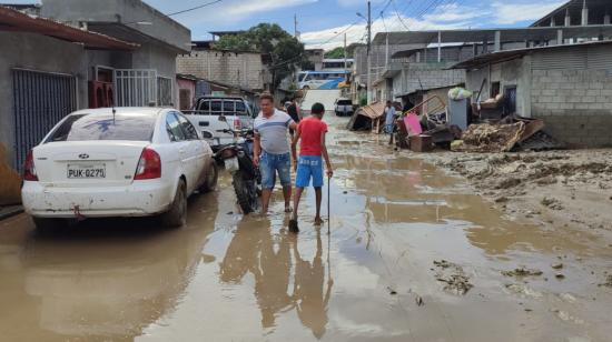 Habitantes del sector La Propicia 4, en Esmeraldas, en medio del lodo que dejó el desbordamiento del río Teoane, el 6 de junio de 2023.