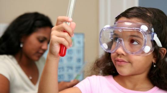 Imagen referencial. Una niña sosteniendo un tubo de ensayo en un laboratorio. 