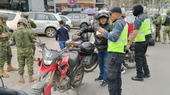 Agentes de tránsito realizan un operativo de control de motos en la Feria Libre, en Cuenca. 