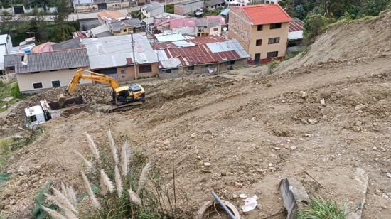 Maquinaria del Municipio limpia el material que cayó en el barrio Los Pinos Altos, en Cuenca. 