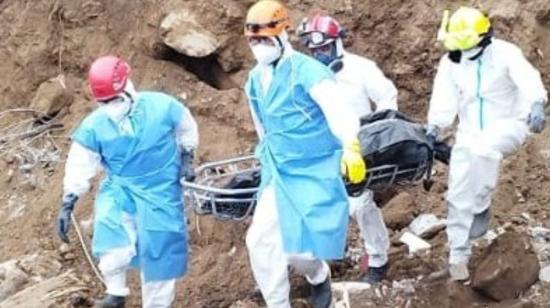 Rescatistas de Bomberos de Cuenca recuperan un cuerpo de la montaña de tierra en Alausí. 