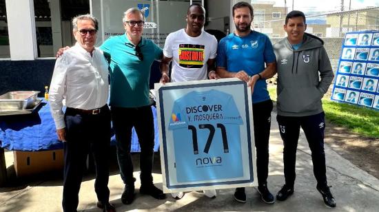 Yuber Mosquera (medio) sostiene una camiseta de Universidad Católica en el complejo de La Armenia, el 19 de junio de 2023.