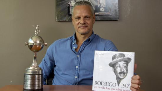 Esteban Paz posa con una réplica del trofeo de la Copa Libertadores y un libro de su padre, en Quito.