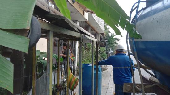 Un trabajador de Interagua entregando el líquido en Bastión Popular, noroeste de Guayaquil, el 29 de junio de 2023. 