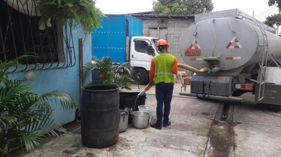 Técnicos de Interagua entregando el líquido en una vivienda de Guayaquil, el 10 de julio de 2023. 