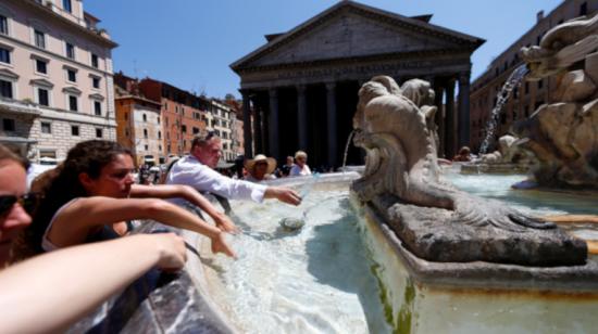 Turistas se refrescan en una fuente del centro de Roma. 