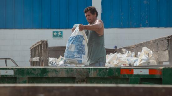 Un ciudadano deposita una funda con desechos en uno de los centros de acopio en Guayaquil, el 20 de julio de 2023. 