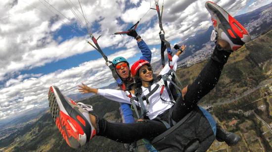 Dos personas vuelan en parapente en Quito.