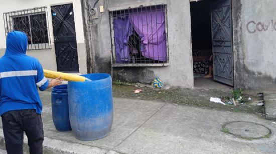 Un trabajador de Interagua entregando el líquido a una vivienda en Guayaquil, el 9 de julio de 2023. 