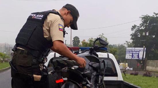 Un policía junto a la moto robada tras un operativo en Santo Domingo, el 1 de agosto de 2023. 