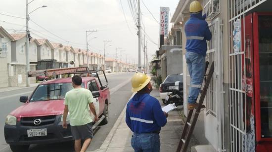 Dos empleados de CNEL EP verificando una conexión en Guayaquil, el 31 de julio de 2023. 