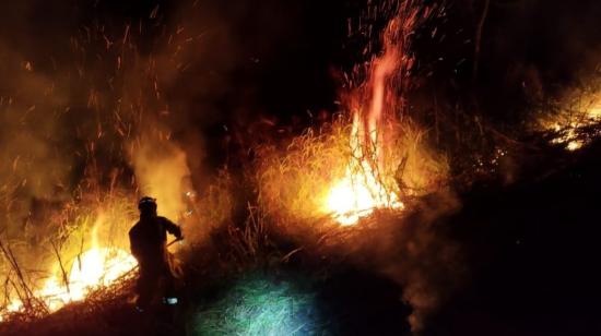 Bomberos intentan apagar un incendio forestal en Ecuador.