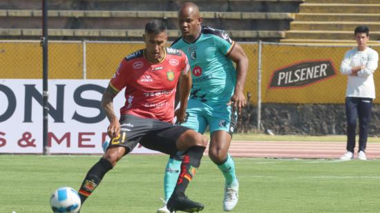 Raúl Becerra, del D. Cuenca, cubre una pelota ante un jugador de Cumbayá, en el estadio Atahualpa, el 18 de agosto de 2023.