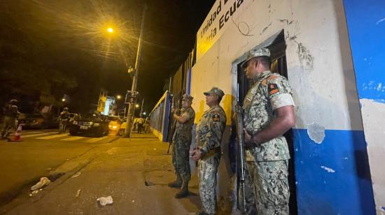 Tres militares custodian una escuela en Guayaquil, que servirá como recinto electoral en las presidenciales, 16 de agosto de 2023. 