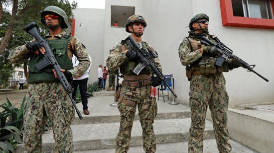 Tres militares fuertemente armados custodian un recinto electoral en Guayaquil, el 20 de agosto de 2023. 