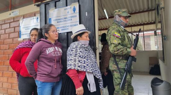 Tres mujeres en fila durante las elecciones anticipadas, en un recinto electoral de Cuenca, el 20 de agosto de 2023. 