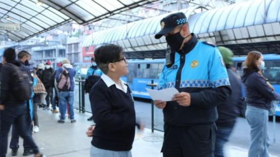 Un agente metropolitano da información a un estudiante en Quito.